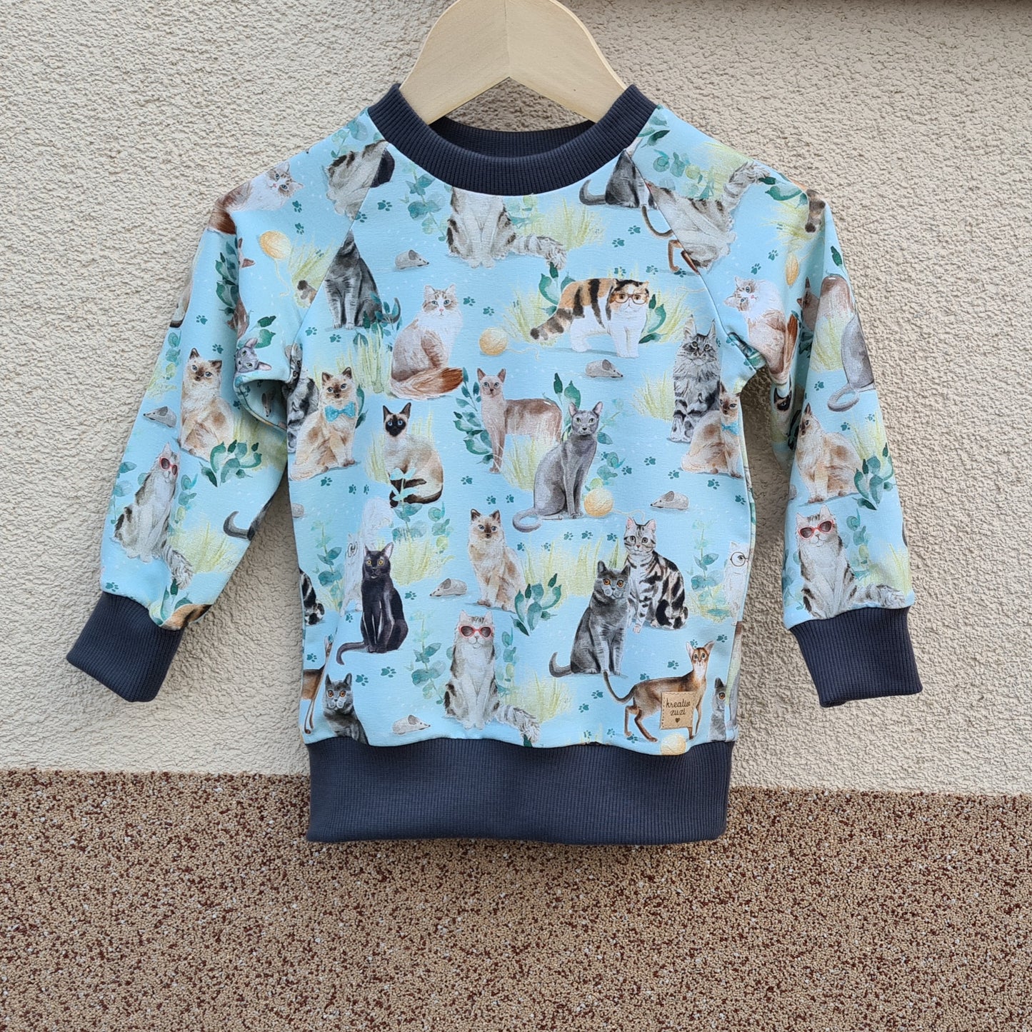 handmade mikina na svotlomodrom podklade so vzorom rôznych druhov mačiek