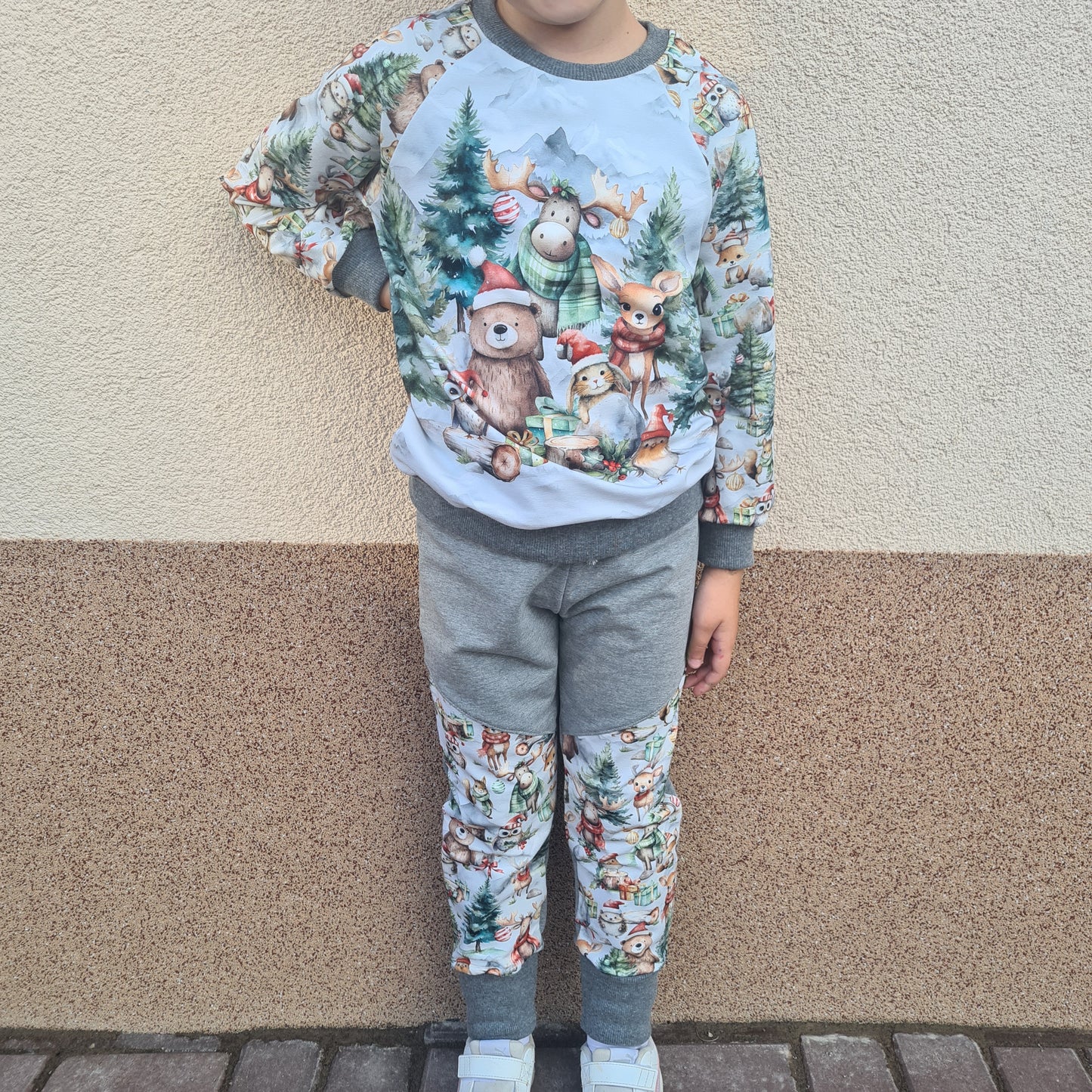 unisex detské handmade tepláky vianočný les a šalviová teplakovina šikmo členené so zimným vzorom, ideálna na zimné a vianočné obdobie, foto na postave