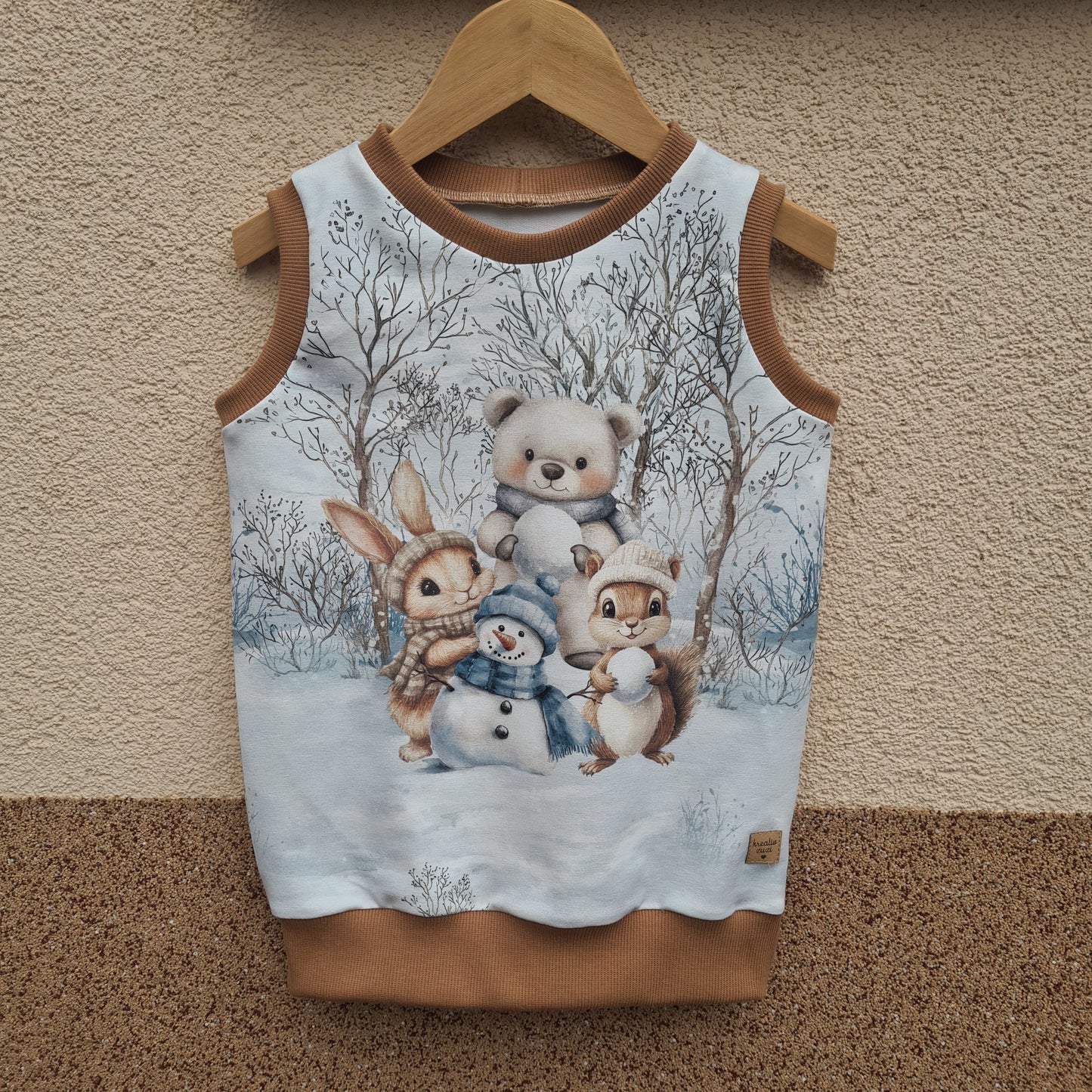 detská vesta s motívom zimy, vianoc, zvieratká, hra na snehu. foto na vešiaku