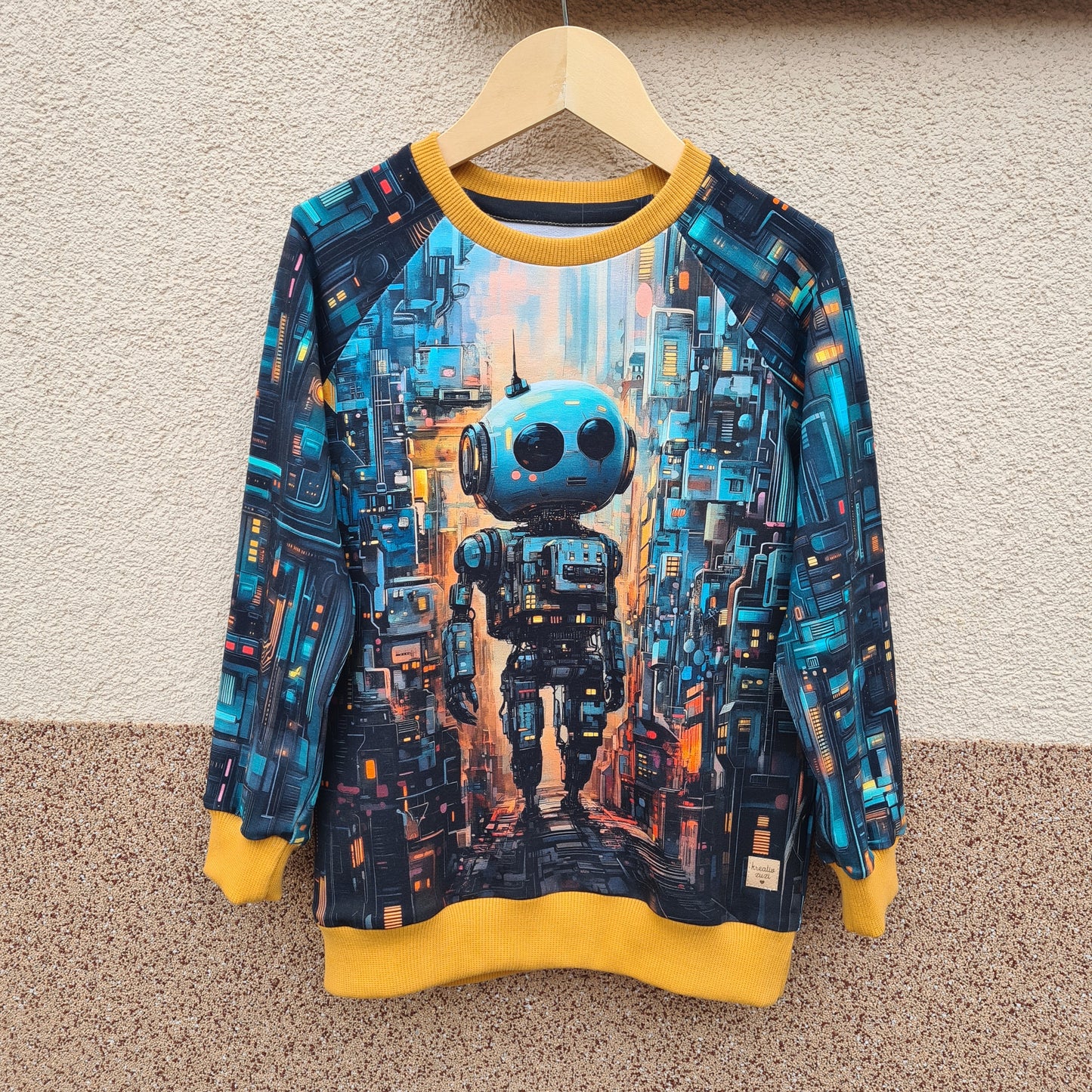 Ilustrácia robota na detskej mikine, inšpirovaná futuristickým mestom