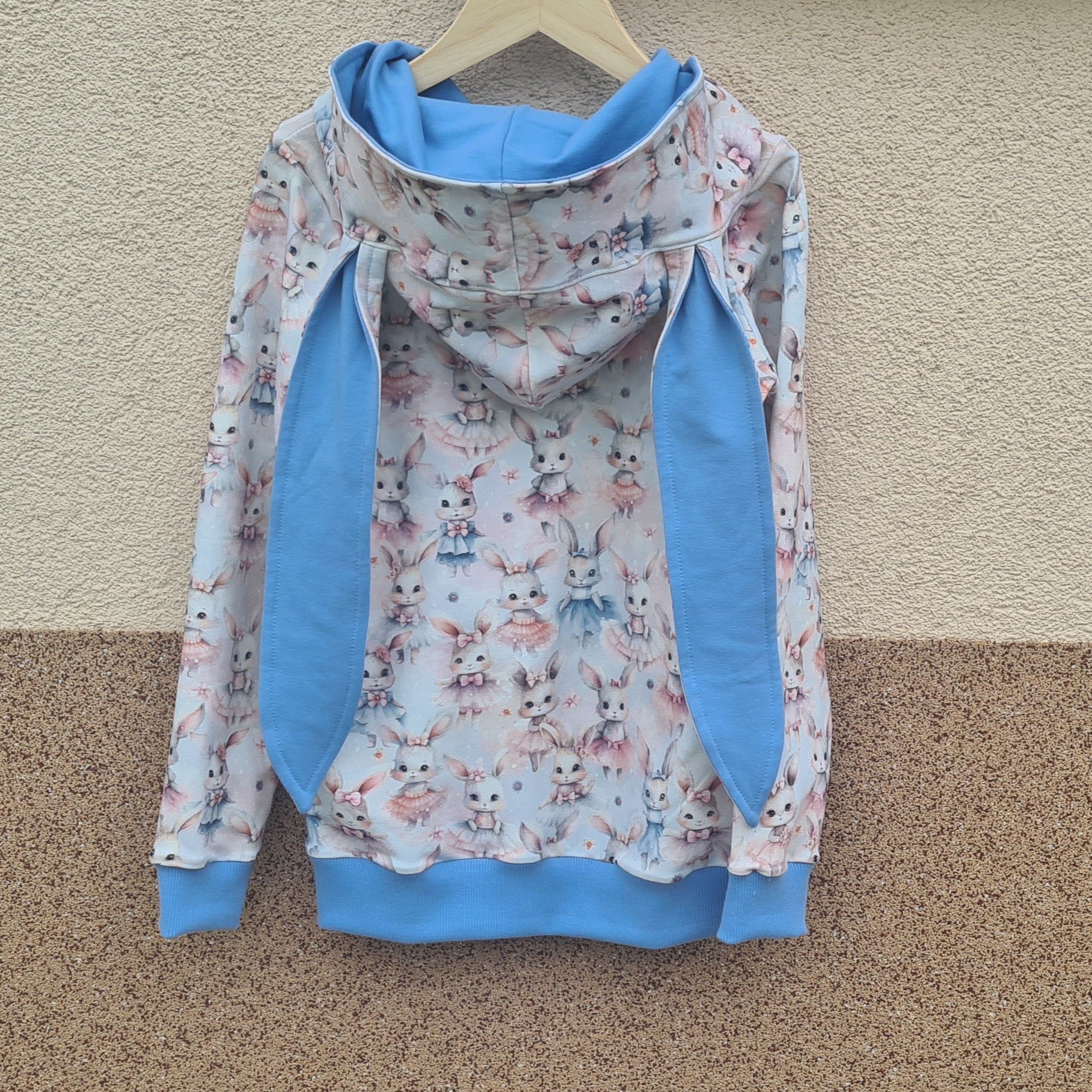 handmade ušatá mikina so zajkom, foto na vešiaku, pohľad zozadu, modré patenty