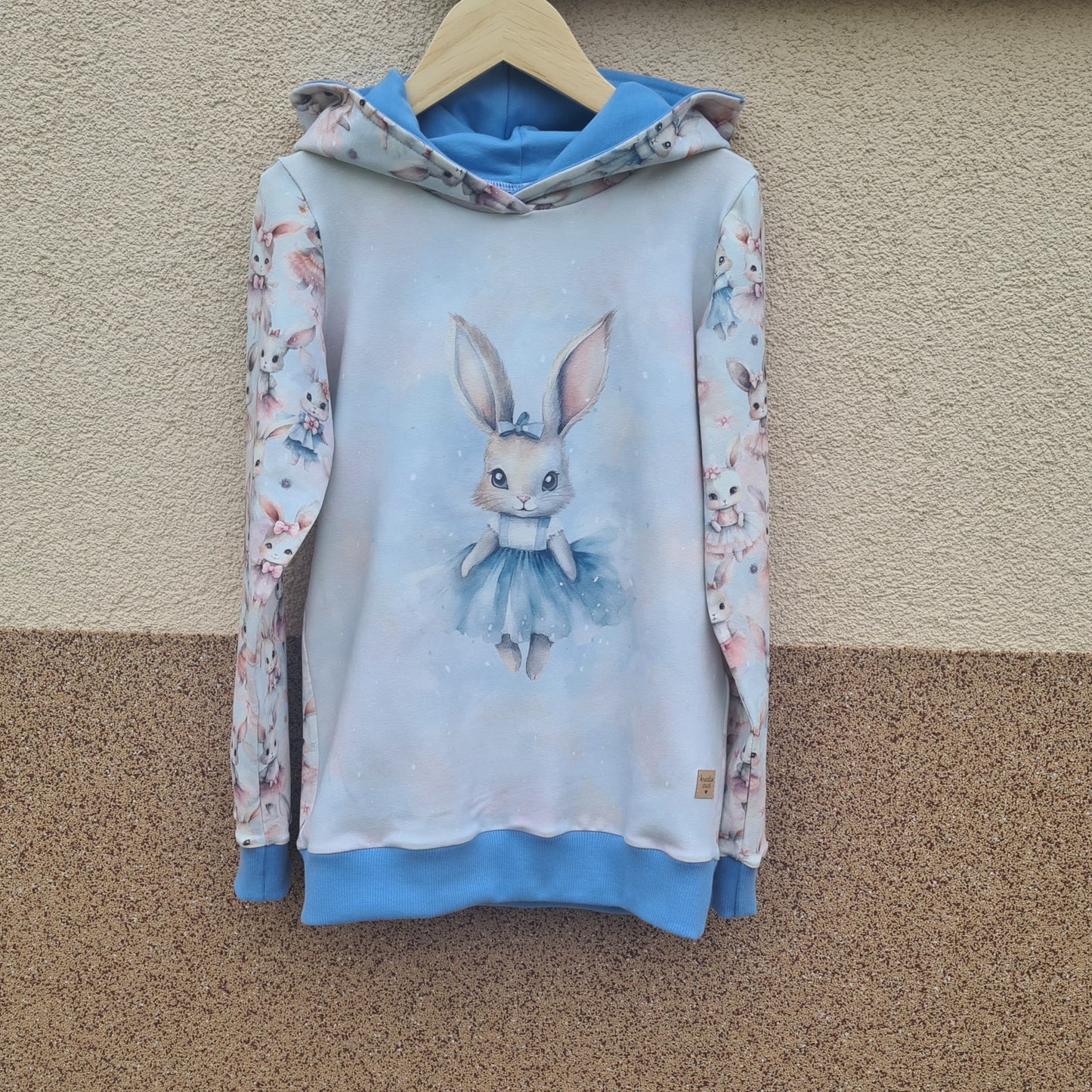 handmade ušatá mikina so zajkom, foto na vešiaku, pohľad zpredu, modré patenty