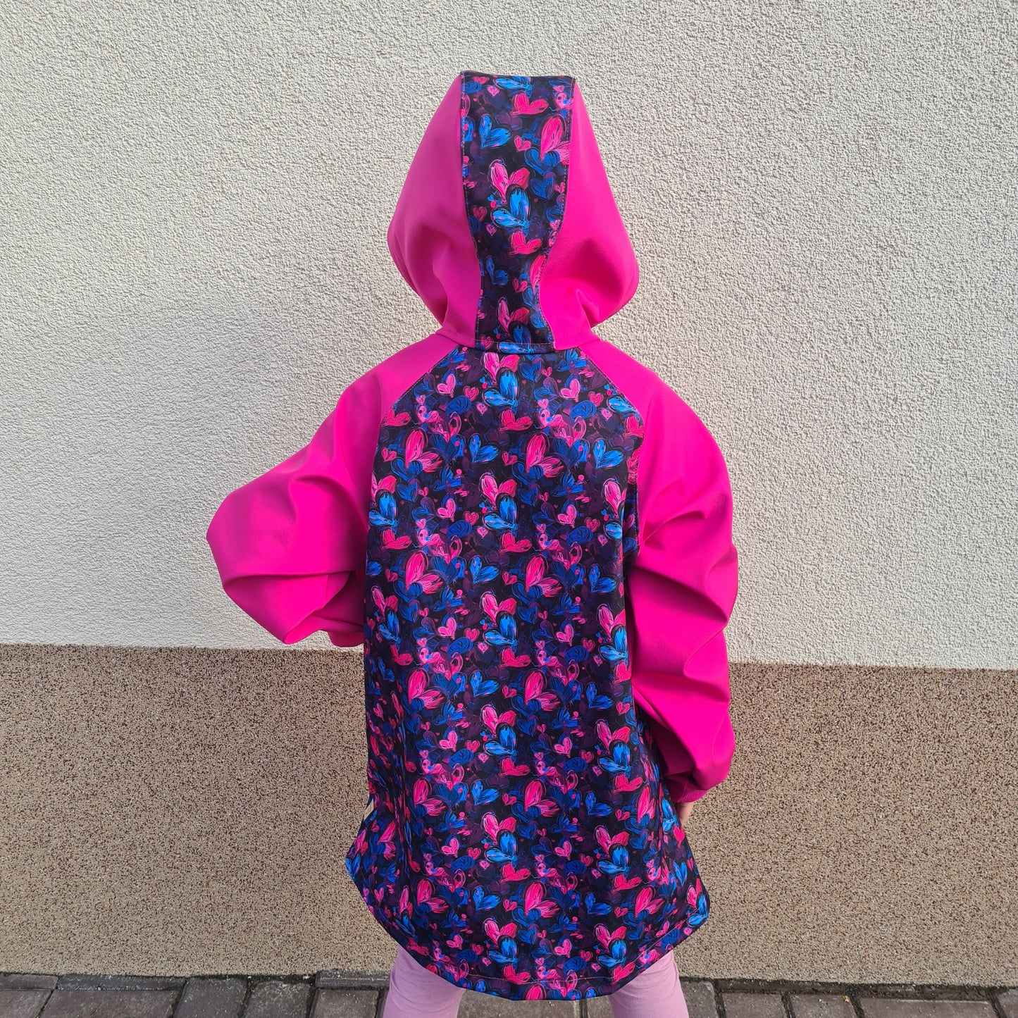 detská softshellová bunda s kapucňou, na zips, s vreckami, rastúca veľkosť, patenty, softshellová bunda cyklámenová so srdiečkami, motív srdiečka, farba cyklámenová, foto na postave, pohľad zozadu