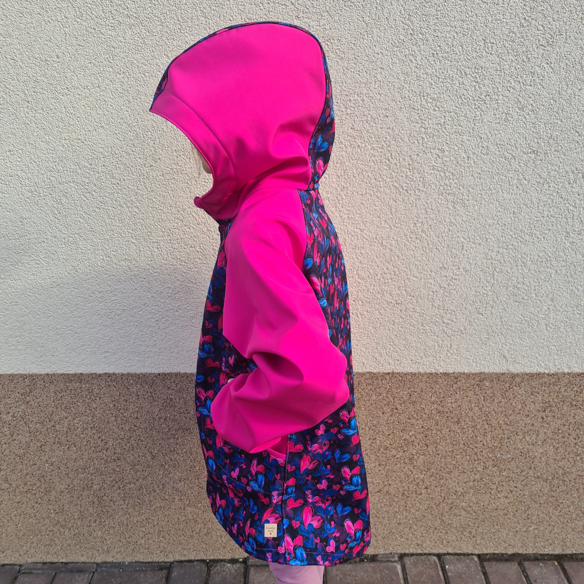 detská softshellová bunda s kapucňou, na zips, s vreckami, rastúca veľkosť, patenty, softshellová bunda cyklámenová so srdiečkami, motív srdiečka, farba cyklámenová, foto na postave, pohľad zboku