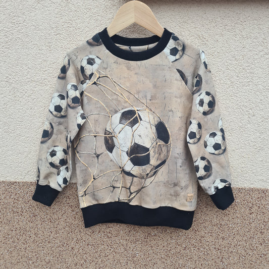 chlapčenská mikina s motívom futbalovej lopty. patent čierny. foto na  vešiaku 
